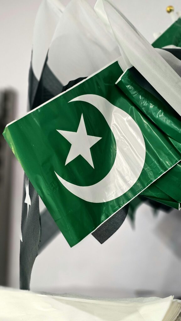 A close-up of Pakistan's national flag showcasing the crescent and star symbols.